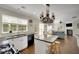 Open kitchen features black countertops, white cabinets, an island and stainless steel appliances at 690 Floral Pl, Suwanee, GA 30024