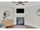 Bright living room showcasing a fireplace with mounted TV, elegant mantle, and hardwood flooring at 690 Floral Pl, Suwanee, GA 30024