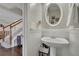 Charming powder room features pedestal sink, white wainscoting, and stylish mirror at 690 Floral Pl, Suwanee, GA 30024