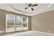 Spacious main bedroom featuring large windows, a tray ceiling, and a ceiling fan, bathed in natural light at 916 Santa Anita Dr, Woodstock, GA 30189