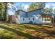 View of home's backyard, featuring ample green space and partial exterior of home with portico at 1270 Graymont Sw Dr, Atlanta, GA 30310
