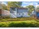 View of the spacious backyard featuring lush green grass, partial home exterior, and mature trees at 1270 Graymont Sw Dr, Atlanta, GA 30310