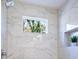 Bright bathroom featuring marble-style tile surround, niche shelving and a garden window at 1270 Graymont Sw Dr, Atlanta, GA 30310