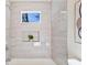Bright bathroom featuring marble-style tile surround, niche shelving and a garden window at 1270 Graymont Sw Dr, Atlanta, GA 30310