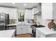 White kitchen featuring stainless steel appliances and large windows for natural light at 1270 Graymont Sw Dr, Atlanta, GA 30310