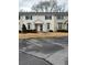 Townhouse with a beige exterior, black shutters, trimmed shrubbery, and front door metal security gate at 1625 Conley Rd # 171, Conley, GA 30288