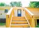 Back porch with wooden stairs leading to a blue door on a painted brick house at 1975 Glenmar Dr, Decatur, GA 30032