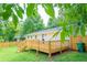 Spacious backyard with a deck, stairs, and white brick house at 1975 Glenmar Dr, Decatur, GA 30032