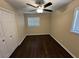 Cozy bedroom with hardwood floors, neutral paint, a ceiling fan, and two windows for natural light at 1975 Glenmar Dr, Decatur, GA 30032