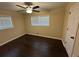 Bright bedroom with hardwood floors, lighted ceiling fan, and two windows for natural light at 1975 Glenmar Dr, Decatur, GA 30032