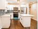 Modern kitchen featuring white cabinets, stainless steel appliances, kitchen island, and tiled backsplash at 1975 Glenmar Dr, Decatur, GA 30032