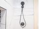 Modern shower head with handheld attachment, set against marble-look tile featuring elegant veining at 1975 Glenmar Dr, Decatur, GA 30032