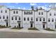 View of newly constructed townhouse exteriors with white siding, garages, and landscaping at 3156 Washburn Sw St, Atlanta, GA 30354