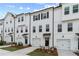 Townhouse exterior showcasing white siding, black accents, garages, and newly planted landscaping at 3156 Washburn Sw St, Atlanta, GA 30354