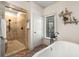 Elegant bathroom features a spacious tiled shower and soaking tub with brick flooring at 3345 Highgate Hills Ne Dr, Duluth, GA 30097