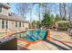 Refreshing backyard pool with brick patio, an outdoor fireplace, and lush greenery at 3345 Highgate Hills Ne Dr, Duluth, GA 30097