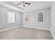 Spacious bedroom featuring neutral walls, three windows, modern ceiling fan, and light hardwood floors at 884 N Eugenia Nw Pl, Atlanta, GA 30318