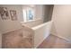 Upstairs hallway and staircase with neutral carpet and wall art at 1027 Northfield Dr, Conyers, GA 30013