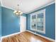 Dining room with blue walls, hardwood flooring, large windows, and an elegant chandelier at 185 Stayman Park, Fayetteville, GA 30215