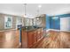 Kitchen island with granite countertop and stainless steel dishwasher with living room and fireplace in the background at 185 Stayman Park, Fayetteville, GA 30215