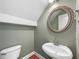 Small powder room featuring a corner sink, toilet, and decorative mirror at 185 Stayman Park, Fayetteville, GA 30215