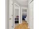 Hallway leading to a bedroom and bathroom; features wood floors and white doors at 27 Gatepost Ln, Kingston, GA 30145