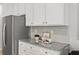 Close-up of kitchen featuring stainless steel refrigerator, granite counters and tiled backsplash at 1029 Northfield Dr, Conyers, GA 30013