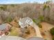 Aerial view of a two-story home with a long driveway, surrounded by mature trees, showcasing the property's curb appeal at 2358 Alexander Farms Sw Ct, Marietta, GA 30064