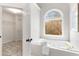 Bright bathroom featuring a soaking tub with tile surround and a large window offering natural light at 2358 Alexander Farms Sw Ct, Marietta, GA 30064