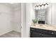 Bathroom featuring a black vanity, mirror with decorative lighting, and walk-in closet at 2358 Alexander Farms Sw Ct, Marietta, GA 30064
