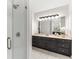 Modern bathroom with a glass-enclosed shower, black vanity, and stylish mirror with decorative lighting at 2358 Alexander Farms Sw Ct, Marietta, GA 30064