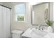 Bright bathroom with a large mirror, modern vanity, white tile, and a window letting in natural light at 2358 Alexander Farms Sw Ct, Marietta, GA 30064
