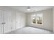 This bedroom features neutral walls, carpet flooring, a ceiling fan, and a window allowing for natural light at 2358 Alexander Farms Sw Ct, Marietta, GA 30064
