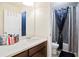 Bathroom featuring a vanity with dark wood cabinets, a white countertop, and a shower with blue accents at 2463 Turnbury Glen Walk, Snellville, GA 30078
