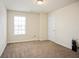 Neutral bedroom featuring plush carpet, bright natural light from a window, and a white interior door at 2463 Turnbury Glen Walk, Snellville, GA 30078