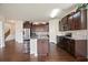 Spacious kitchen features dark wood cabinets, stainless appliances, granite counters, and an island with bar stool seating at 2463 Turnbury Glen Walk, Snellville, GA 30078