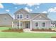 Charming two-story home with a covered front porch, gray siding, and a well-maintained lawn at 3639 Olive Grove Ln, Covington, GA 30016