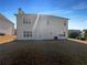 Backyard view of a light-colored two-story home with well-placed windows at 4028 Elm Trace Dr, Loganville, GA 30052