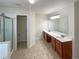 Bright bathroom featuring a shower and a double sink vanity with tile floor at 4028 Elm Trace Dr, Loganville, GA 30052