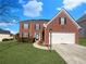 Charming two-story brick home featuring a well-manicured lawn and attached two-car garage at 4028 Elm Trace Dr, Loganville, GA 30052