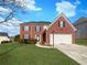 Charming two-story brick home featuring a well-manicured lawn and attached two-car garage at 4028 Elm Trace Dr, Loganville, GA 30052