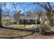 Wide open backyard showing the house, grass, gravel, a stone pathway, and a pergola at 1802 S Gordon Sw St, Atlanta, GA 30310