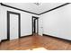 Bedroom featuring hardwood floors, white walls, black trim, closet and door at 1802 S Gordon Sw St, Atlanta, GA 30310