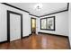 Bedroom with hardwood floors, white walls, black trim, closet, door leading to bathroom, and two windows at 1802 S Gordon Sw St, Atlanta, GA 30310