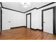 Spacious bedroom featuring hardwood floors, white walls, black trim, closet, and multiple doors at 1802 S Gordon Sw St, Atlanta, GA 30310