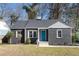 Charming single-story home with a gray brick exterior, bright blue front door, and well-maintained landscaping at 1802 S Gordon Sw St, Atlanta, GA 30310