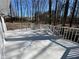 An outside view of a back deck with white railing surrounded by a lush forest and blue skies at 5718 Denson Blvd, Morrow, GA 30260