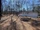 The backyard features a lush, natural landscape, white brick, a patio, and a mature tree line at 5718 Denson Blvd, Morrow, GA 30260