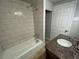 Bathroom features a dark vanity with granite countertops, a bathtub with subway tile surround at 5718 Denson Blvd, Morrow, GA 30260