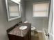 Bathroom features a dark vanity with granite counters, a bathtub, and a window at 5718 Denson Blvd, Morrow, GA 30260